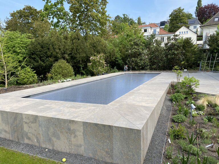 Winkelverkleidung aus Naturstein rund um einen Pool