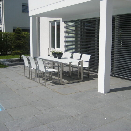 Dunkle Escura Granitplatten als Terrassen- und Poolumrandung, modern verlegt.