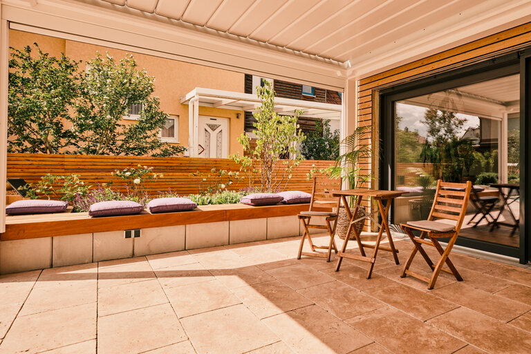 Terrasse mit Finca Beige Travertin und Holzelementen Terrasse mit Finca Beige Travertin, Holzelementen und stilvollen Sitzgelegenheiten.
