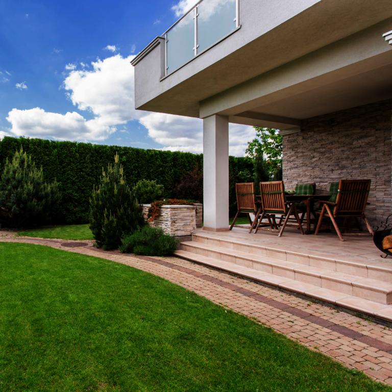 Privatgarten mit Natursteinfassade, Bodenplatten und Blockstufen.