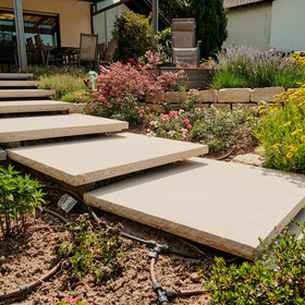 Schwebstufen aus Kanfanar Kalkstein als Podeststufen zwischen Terrasse und Garten.