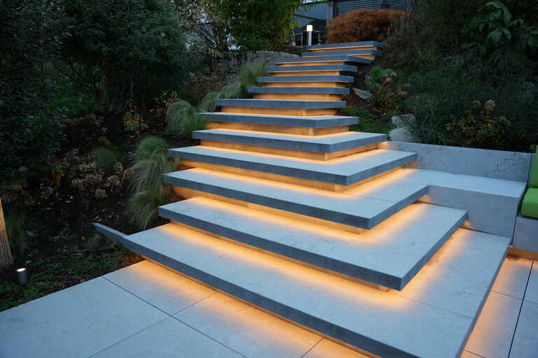 Schwebstufen Treppe aus Belgisch Blau Naturstein mit LED Unterleuchtung für moderne Gärten
