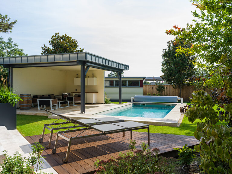 Pool mit Poolrandplatten aus Muschelkalk im Garten Pool mit Poolrandplatten aus Muschelkalk, umgeben von einem modernen Garten.