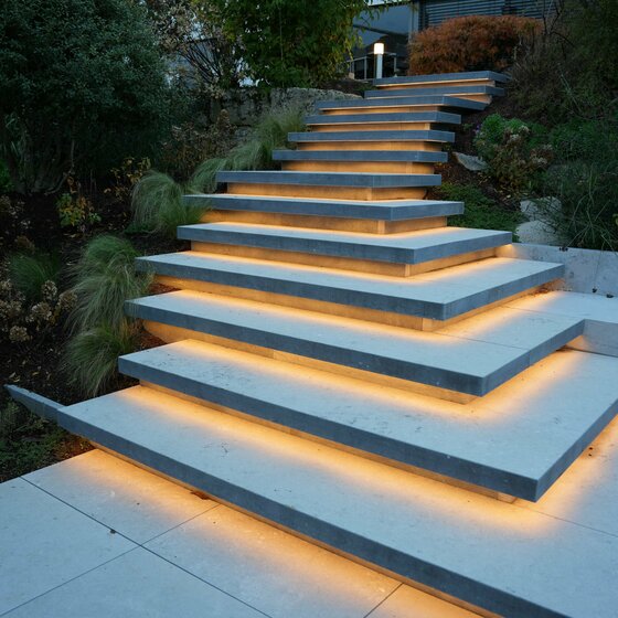 Schwebstufen aus Belgisch Blau Naturstein mit LED-Unterleuchtung für moderne Treppen
