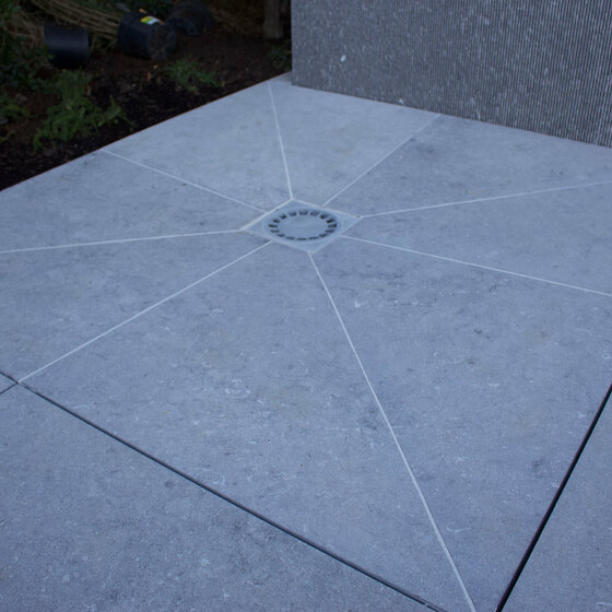 Detailaufnahme Belgisch Blau Bodenplatte mit Abfluss für Outdoor Dusche im Gartenprojekt