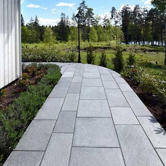 Graue Oppdal Bodenplatten aus Quarzit elegant verlegt im grünen Gartenbereich