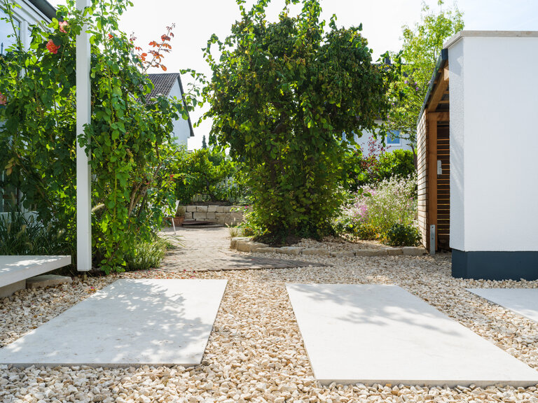 Jura Bodenplatten mit Kieseinbettung im mediterranen Garten Große Jura Bodenplatten mit Kieseinbettung in einem mediterranen Garten.