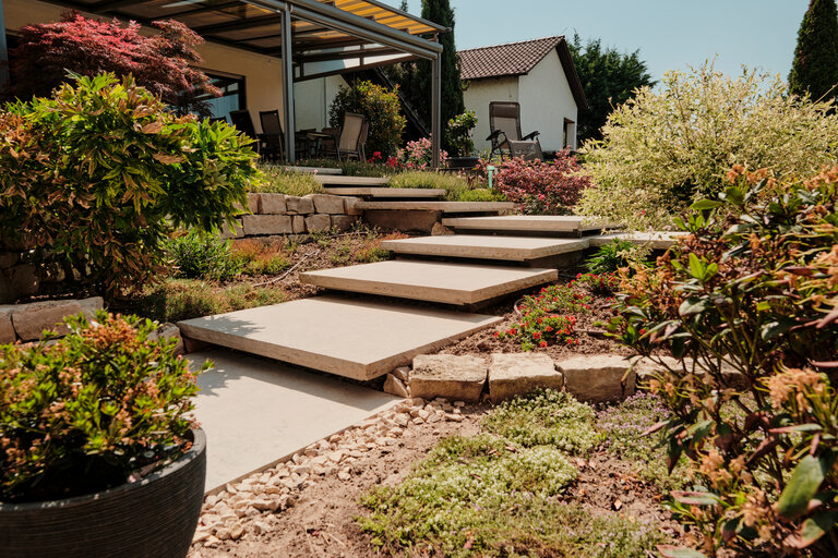 Große Treppe aus Schwebstufen aus Kanfanar Kalkstein im Garten Große Treppe aus Schwebstufen aus Kanfanar Kalkstein in einem modernen Garten.