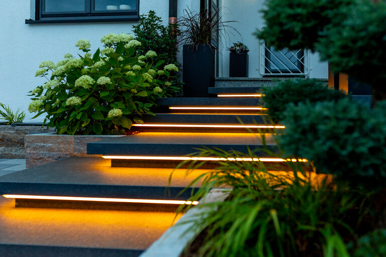 Schwebstufen aus Nero Assoluto Naturstein mit LED-Unterleuchtung für stilvolle Treppen