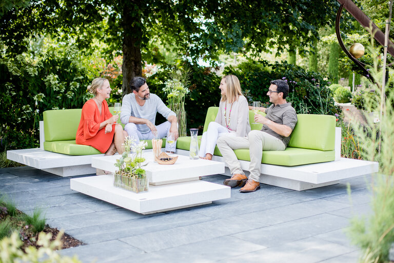Lounge Möbel Bianco Adria mit grüner Polsterung und Gästen im Garten