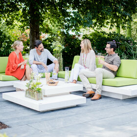 Lounge Möbel Bianco Adria mit grüner Polsterung und Gästen im Garten