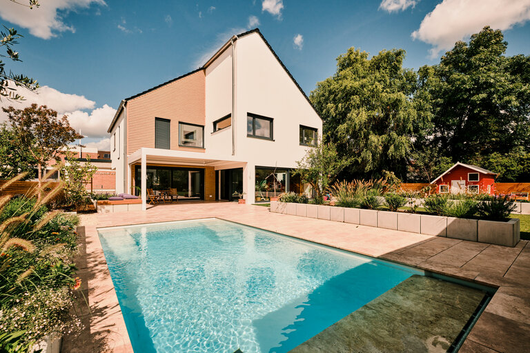 Pool mit Boden- und Poolrandplatten aus Finca Beige Travertin in mediterranem Garten.
